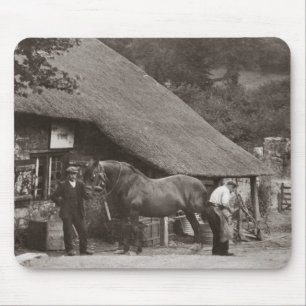 Blacksmith shoeing a horse mouse pad