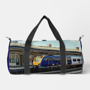 Blue and yellow train , at the station duffle bag
