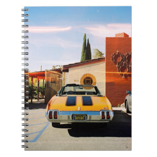 Blue car parked beside brown concrete building in notebook