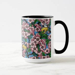 Blue tit birds in the blooming cherry tree on blue mug