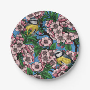 Blue tit birds in the blooming cherry tree on blue paper plate