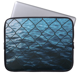 Body of water in front of chain link fence laptop sleeve
