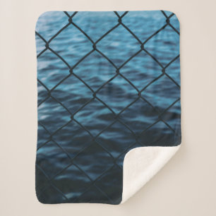Body of water in front of chain link fence sherpa blanket