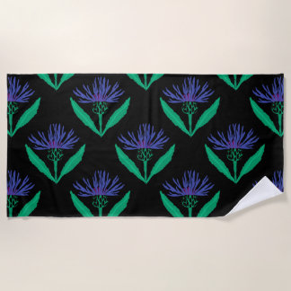 Bold blue cornflower on black beach towel