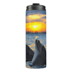 Bottlenose dolphins, sunset ocean scene. thermal tumbler