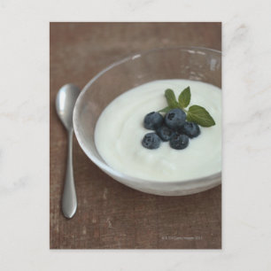 Bowl of yoghurt with blueberry on table postcard