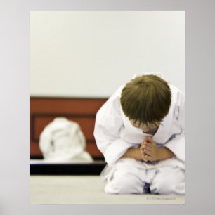 Boy (4-5 years) wearing karate outfit bowing, poster