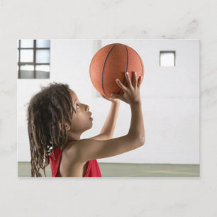 Boy aiming a shot with a basketball in a school postcard
