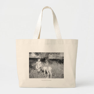 Boy feeding antelope by hand large tote bag