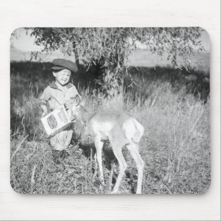Boy feeding antelope by hand mouse pad