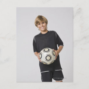 Boy holding soccer ball, smiling, portrait postcard