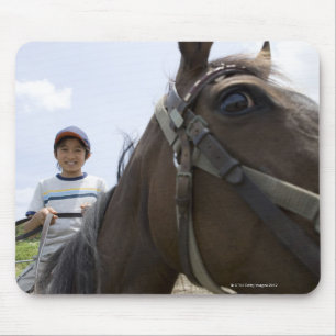 Boy riding a horse mouse pad