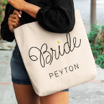 Bride Modern Script Gold Heart Wedding Name Tote Bag<br><div class="desc">This modern tote bag with a minimalist casual chic script calligraphy design reading Bride as well as your custom name features clean lines to create a sleek and sophisticated appearance. The understated style with the little printed gold heart detail adds a touch of sophistication to her wedding day look.</div>