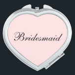 Bridesmaid Compact Mirror<br><div class="desc">Compact mirror shown in a heart shape with a blush pink background colour with Bridesmaid text in black.
Customise this item or buy as is.</div>