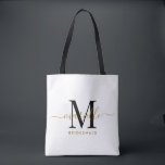Bridesmaid Gift Gold Black Monogram White Tote Bag<br><div class="desc">This Bridesmaid tote bag features a handwritten gold and black script typography monogram with swashes on a white background. Present your bridesmaids with a tote for carrying items the day of the wedding,  and traditionally presented at the rehearsal dinner or before.</div>
