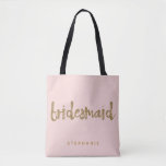 Bridesmaid Gold Glitter Blush PInk Tote Bag<br><div class="desc">This Bridesmaid tote bag is perfect for busy bridesmaids to tote around all their belongings at the bridal shower or the main event. This blush pink tote bag features faux gold glitter style lettering on the front. Personalise these totes with your wedding party member's name on the front and the...</div>