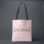 Bridesmaid Gold Glitter Blush PInk Tote Bag<br><div class="desc">This Bridesmaid tote bag is perfect for busy bridesmaids to tote around all their belongings at the bridal shower or the main event. This blush pink tote bag features faux gold glitter style lettering on the front. Personalise these totes with your wedding party member's name on the front and the...</div>