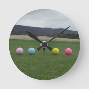 bright coloured Golf Balls on a mountain Round Clock