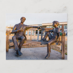 Bronze statue of young and older talking postcard