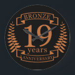 Bronze traditional wedding anniversary 19 years large clock<br><div class="desc">A design to celebrate 19 years of marriage. This design has a bronze coloured laurel design on a black background. Bronze is the traditional gift for this occasion. The text reads bronze 19 years anniversary. A romantic design to celebrate your 19th year of marriage. If you would like any help...</div>