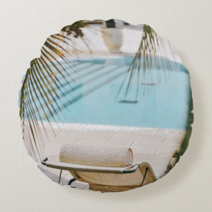 Brown and black armchair beside swimming pool in t round cushion