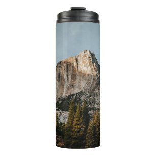 BROWN CLIFF NEAR TREES UNDER BLUE SKY THERMAL TUMBLER