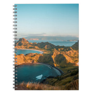 BROWN MOUNTAIN BESIDE BODY OF WATER DURING DAYTIME NOTEBOOK