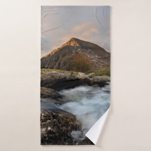 BROWN MOUNTAIN NEAR BODY OF WATER UNDER CLOUDY SKY BATH TOWEL