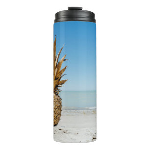 Brown pineapple fruit on seashore thermal tumbler