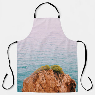 Brown rock mountain on body of water apron
