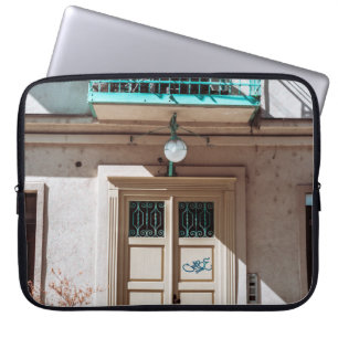 Brown wooden door on white concrete building laptop sleeve