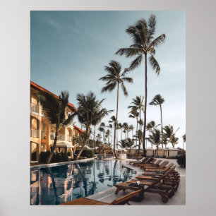 Brown wooden lounge chairs near pool surrounded by poster