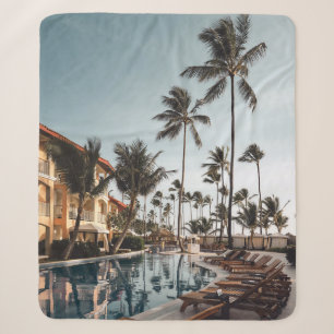 Brown wooden lounge chairs near pool surrounded by sherpa blanket