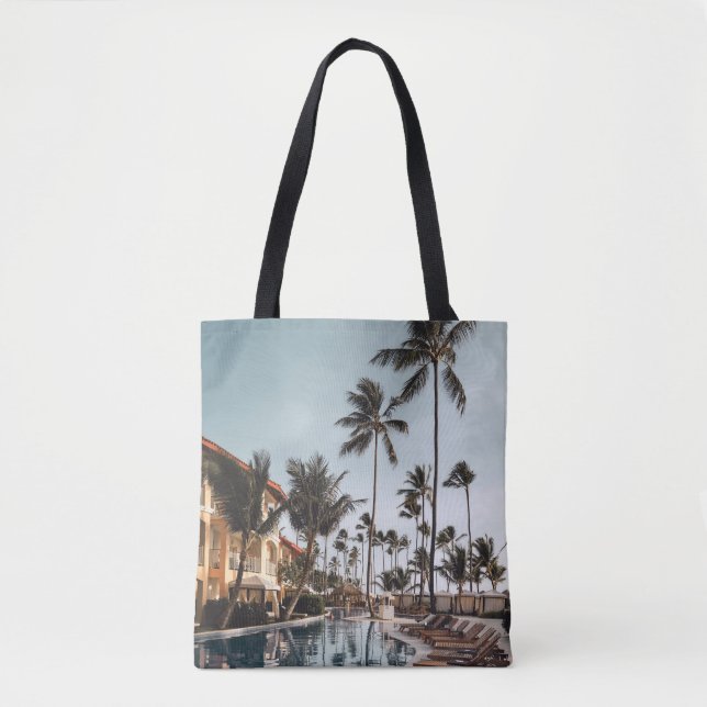 Brown wooden lounge chairs near pool surrounded by tote bag (Front)