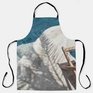 Brown wooden lounger near body of water apron