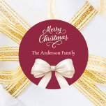 Burgundy cream bow Christmas Classic Round Sticker<br><div class="desc">A burgundy background,  cream coloured text and bow.  Merry Christmas is written with an elegant hand-lettered style script.  Personalise and add your family name.</div>