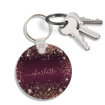Burgundy rose gold glitter dust name script key ring<br><div class="desc">A burgundy faux metallic looking background colour. Decorated with rose gold faux glitter dust. Personalise and add a name. The name is written with a modern hand lettered style script with swashes. To keep the swashes only delete the sample name, leave the spaces or emoji's in front and after the...</div>