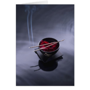 Burning incense on top of bowl of petals