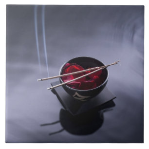 Burning incense on top of bowl of petals tile