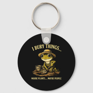 Bury things maybe plants maybe people funny frog key ring