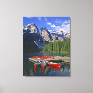 Canada, Alberta, Moraine Lake. Red canoes await Canvas Print