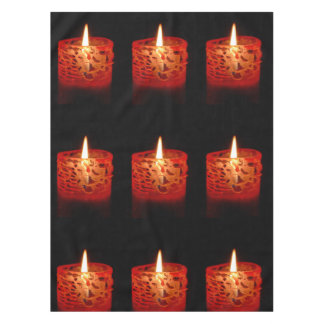 Candle on a black background tablecloth