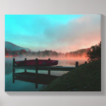Canoe by a lake on a misty morning.