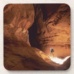 Canyoneer illuminated in the depths of a narrow coaster