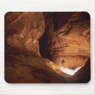 Canyoneer illuminated in the depths of a narrow mouse pad