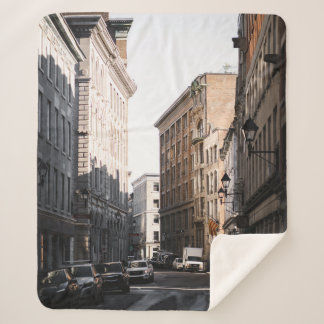 CARS PARKED ON SIDE OF THE ROAD IN BETWEEN BUILDIN SHERPA BLANKET