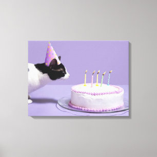 Cat wearing birthday hat blowing out candles on canvas print