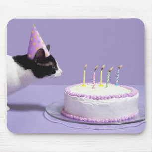 Cat wearing birthday hat blowing out candles on mouse pad