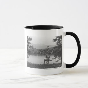 Cattle by a pond with two cowboys. mug