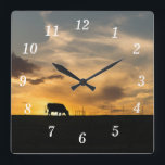 Cattle Sunset Silhouette Wall Clock<br><div class="desc">Wall Clock - A cow eats in front of a beautiful country sunset. This silhouette capture was taken in Ozark, Missouri. Looking for more prints or products? Feel free to visit my store: http://www.zazzle.com/timelessmomentsphtgy This photo was taken by Jennifer White with Timeless Moments Photography. All images are copyrighted © Timeless...</div>